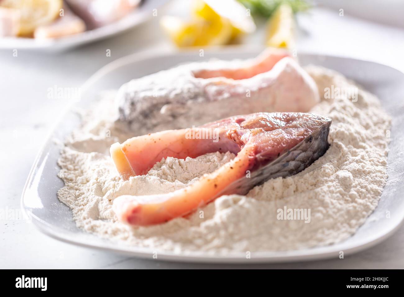Zubereitung von frischem Fisch vor dem Braten durch Einwickeln in Mehl  Stockfotografie - Alamy