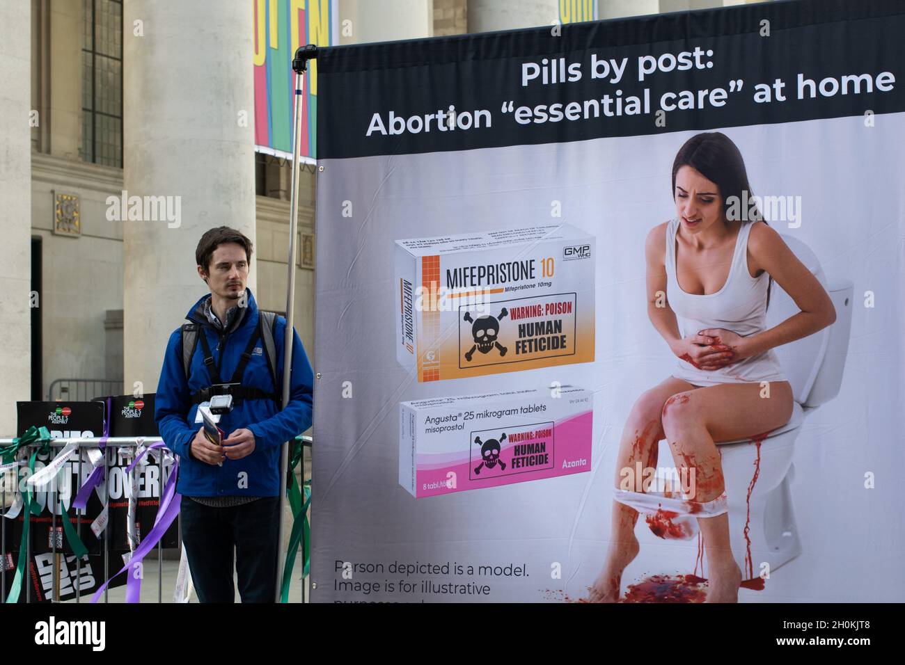 Tory-Parteikonferenz. Protestler mit Bannertext Pills by Post. Abtreibung Essential Care zu Hause. Frau saß mit Blut auf der Toilette. Stockfoto