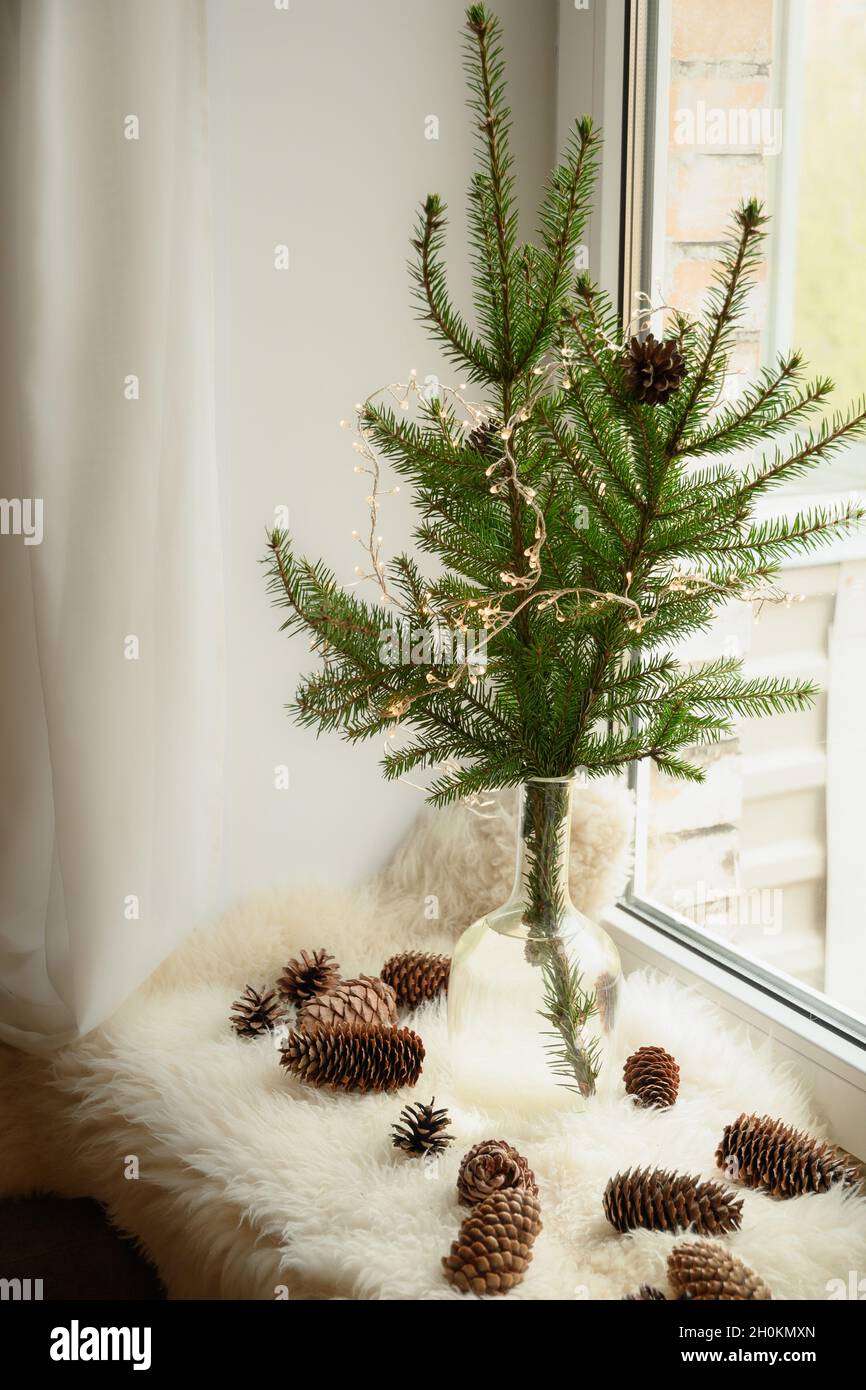 Alternativer Weihnachtsbaum aus natürlichen Zweigen in Vase auf Fensterbank  mit Zapfen verziert Pelzleder. Boxtag. Weihnachtsfeiertag. Gemütliches  Wochenende. Scandy Hygg Stockfotografie - Alamy