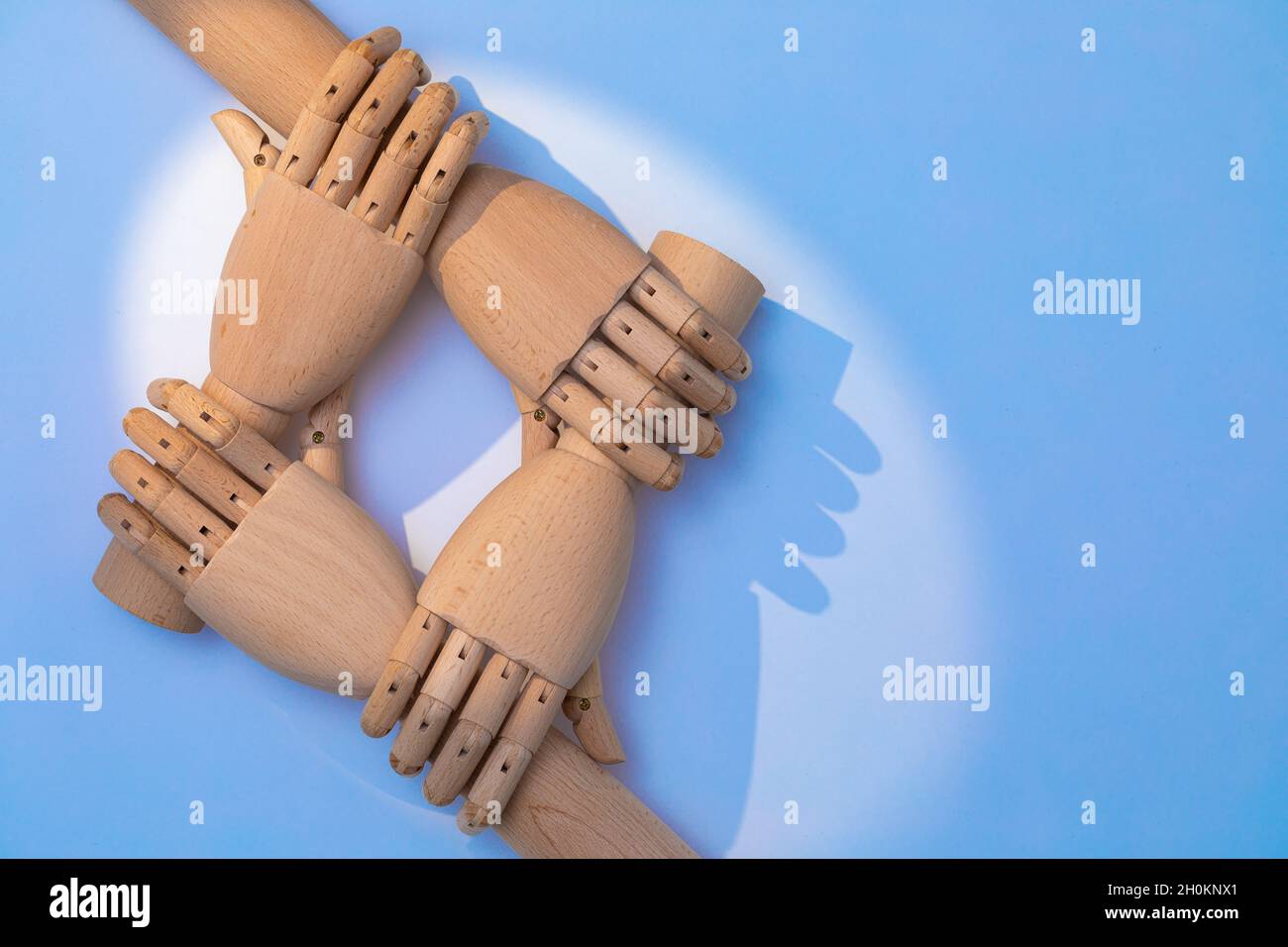 Nahaufnahme der Hände, die sich halten. Zwei Paar prothetische Hände aus Holz sind versetzt angeordnet, um ein kooperatives Erscheinungsbild zu schaffen. Eine Kombination aus Holz ha Stockfoto