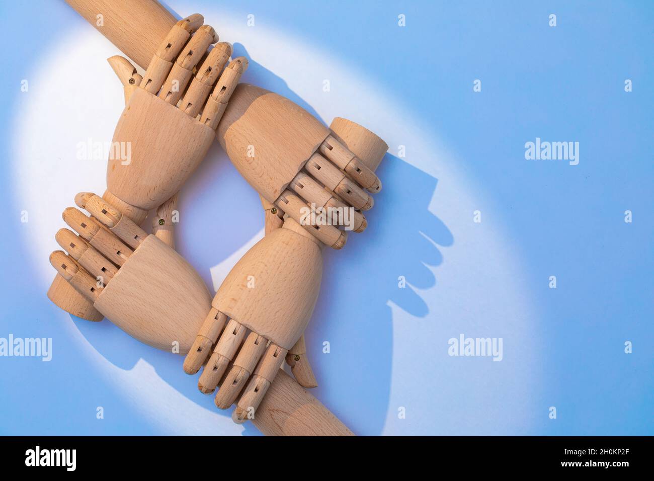Nahaufnahme der Hände, die sich halten. Zwei Paar prothetische Hände aus Holz sind versetzt angeordnet, um ein kooperatives Erscheinungsbild zu schaffen. Eine Kombination aus Holz ha Stockfoto