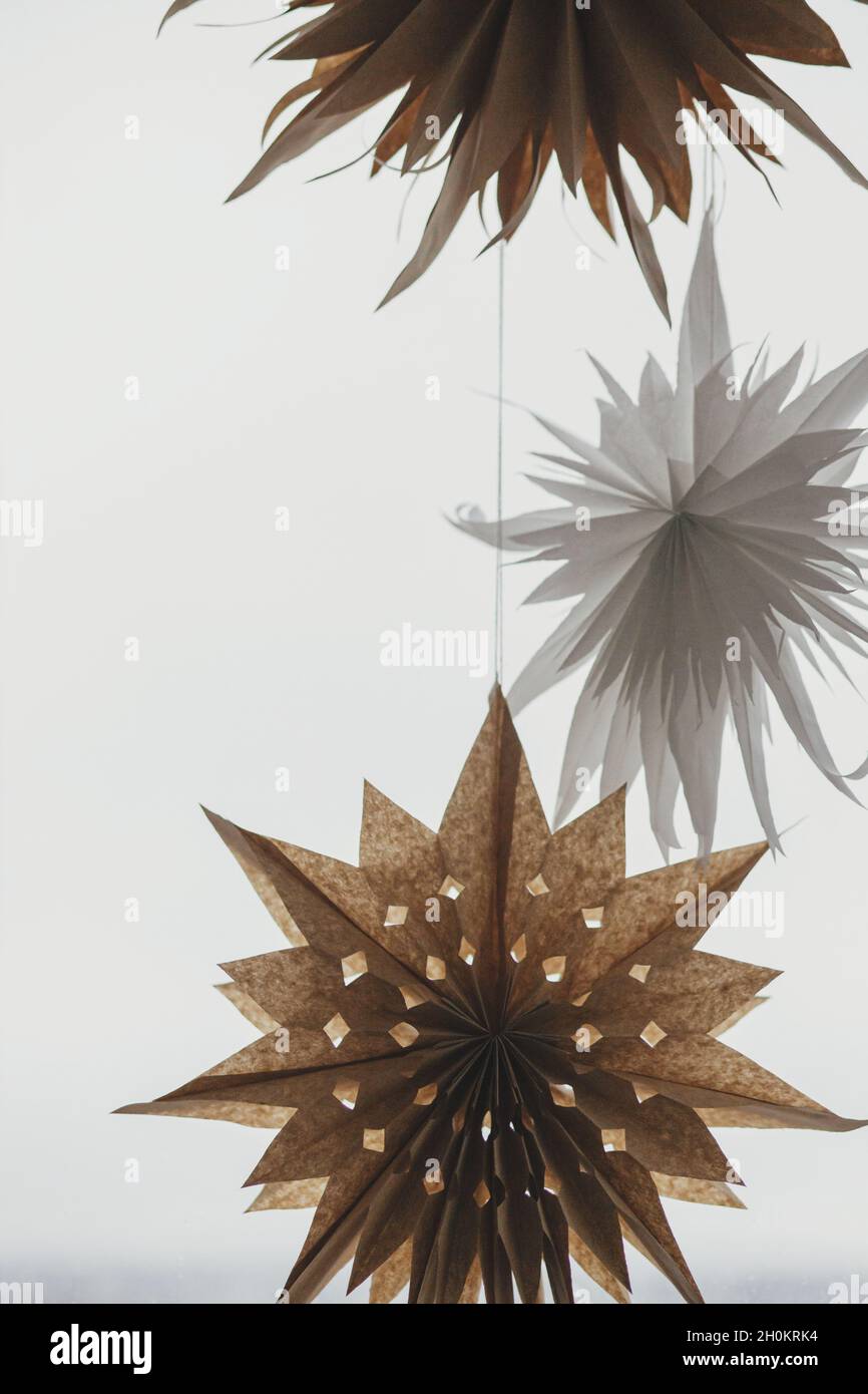 Stilvolle Weihnachtssterne hngen am Fenster. Moderne, festliche  skandinavische Einrichtung im Zimmer. Einfache Handarbeit, weie schweden  Papiersterne. Winter Urlaub preparati Stockfotografie - Alamy