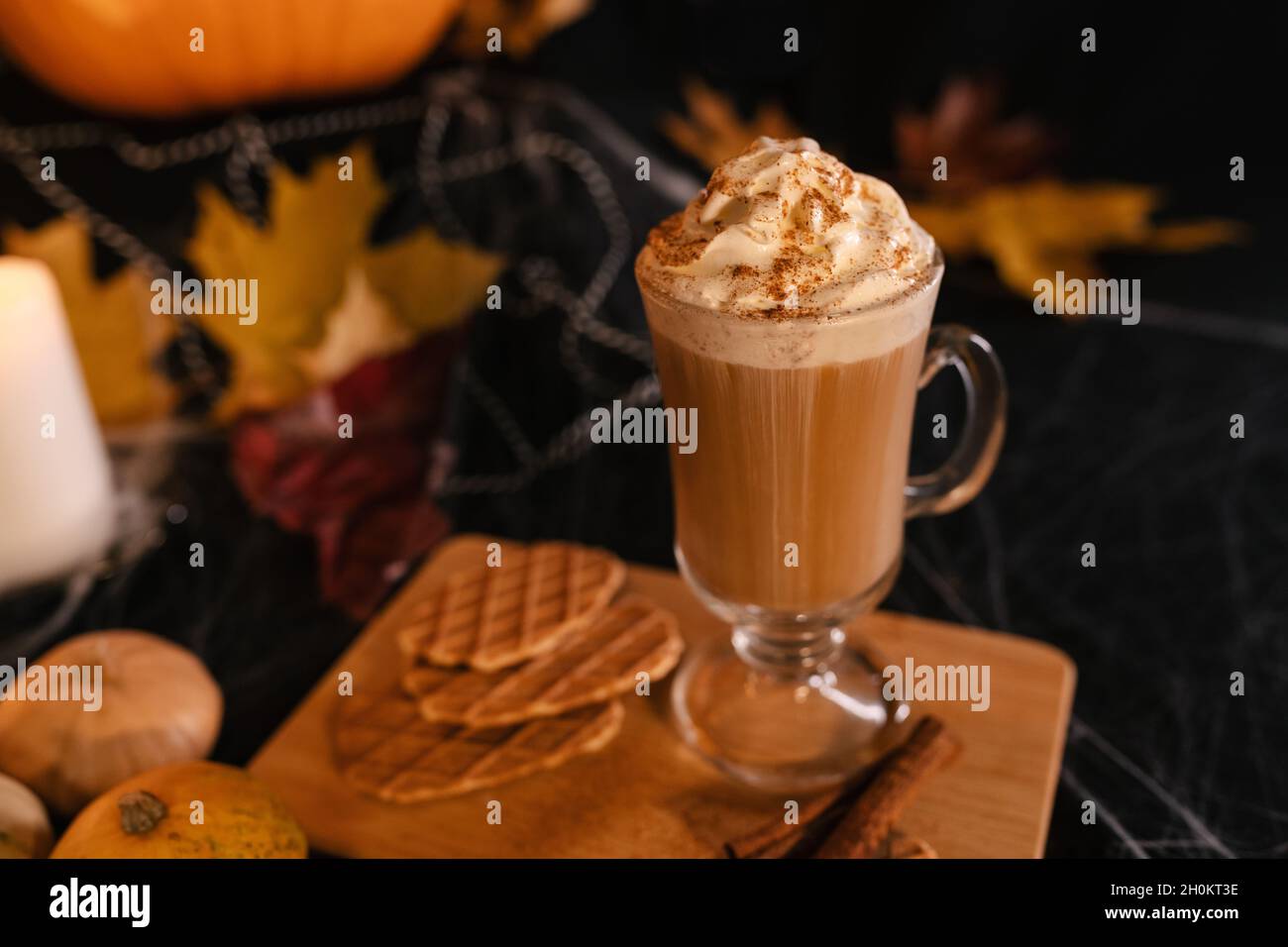 Halloween Latte. Würziger Latte Kaffee in Halloween Dekorationen. Kürbis, Latte, Halloween, Kommerzielle Inhalte. Kaffeetasse auf dem Halloween-Tisch Stockfoto