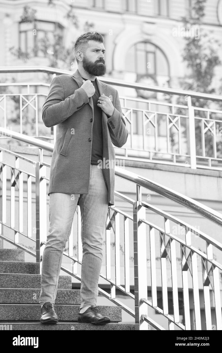 Selbstbewusster männlicher Geschäftsmann in legerer Business-Mode-Jacke gehen in der Straße mit gepflegtem Bart und Frisur, Hipster Stockfoto