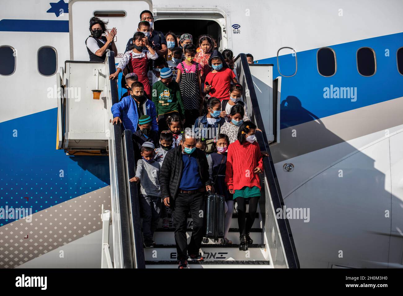 Tel Aviv, Israel. Oktober 2021. Neue jüdische Emigranten aus der indischen Gemeinde Bnei Menashe (Söhne Manasses) steigen am Ben Gurion Airport in der Nähe von Tel aviv aus. 250 Emigranten der Bnei Menashe-Gemeinde, die angeblich zu den zehn verlorenen Stämmen Israels gehören, die sich in Indien niederließen, sind heute im Rahmen einer Operation des Ministers für Aliyah und Integration (Immigrantenabsorption) in Israel angekommen. Quelle: Ilia Yefimovich/dpa/Alamy Live News Stockfoto