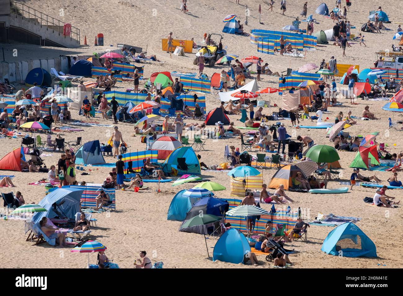 Fistral Beach in Newquay in Cornwall. Urlaubsreisende drängen sich zum Fistral Beach, um die intensive Sommersonne zu genießen. Stockfoto