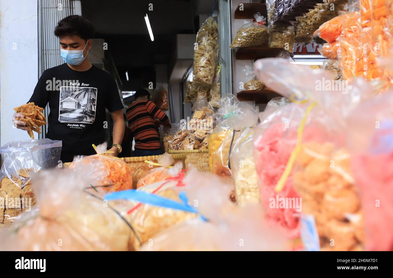 Bandung, Indonesien-September 29,2021: Snack-Händler stecken gebratenen Tempeh in eine Plastiktüte Stockfoto