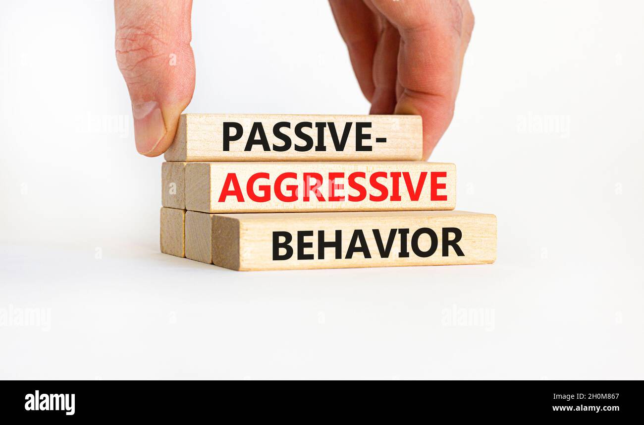Passiv-aggressives Verhaltenssymbol. Konzeptwörter Passiv-aggressives Verhalten auf Holzblöcken. Geschäftsmann Hand. Schöner weißer Hintergrund. Unternehmen Stockfoto