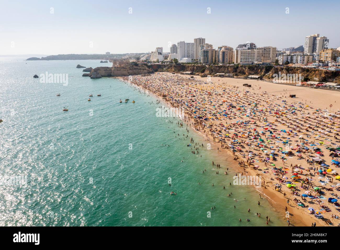 Luftaufnahme des touristischen Portimao mit breiten sandigen Rocha Strand voller Menschen, Algarve, Portugal Stockfoto