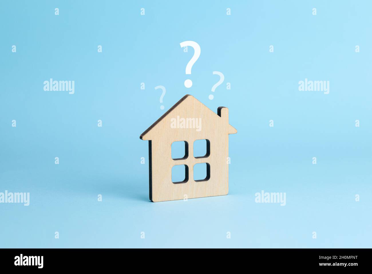 Haus und Fragezeichen. Konzept zur Hausauswahl. Blauer Hintergrund. Stockfoto