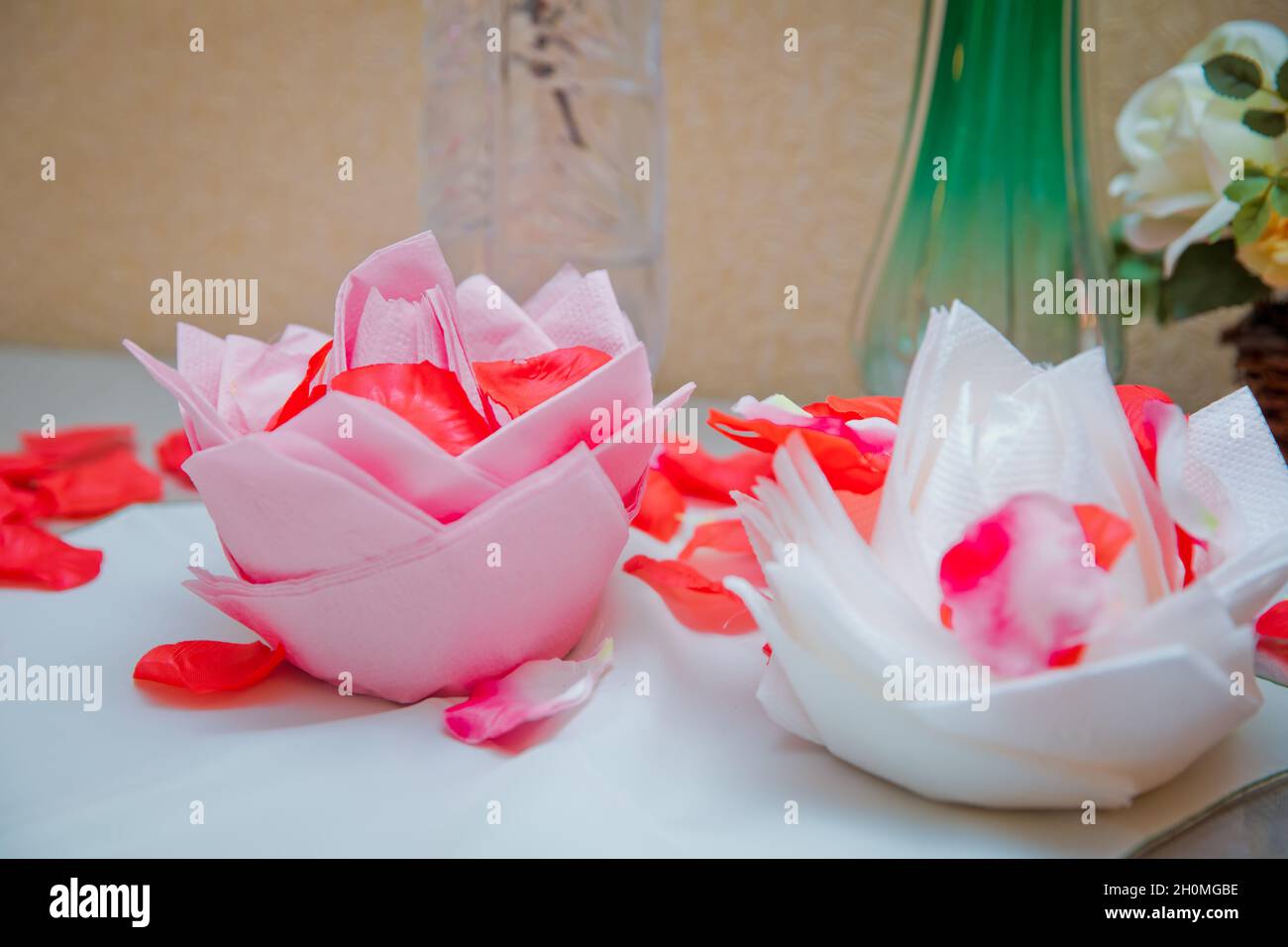 Weiße und rosa Blüten auf Servietten. Schöne Origami-Blume aus Serviette  auf weißem Hintergrund. Blütenblätter einer roten Rose Stockfotografie -  Alamy