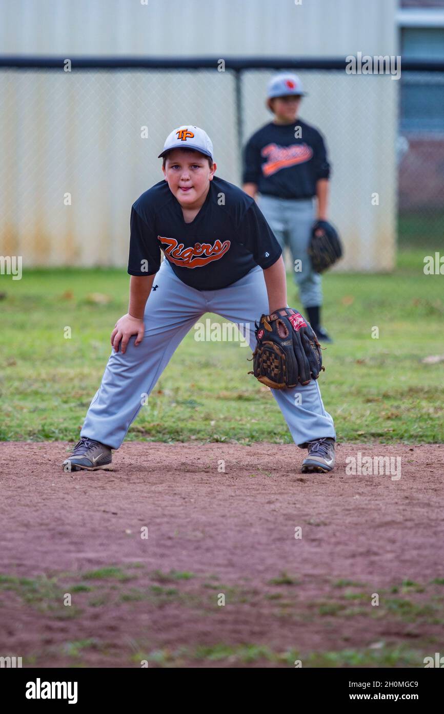 Junger Mann, der in Uniform Baseballspiele spielt Stockfoto
