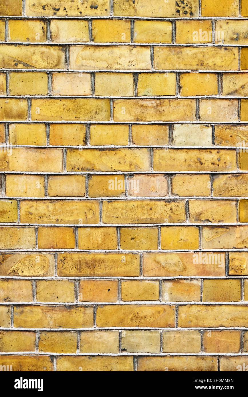 Alte gelbe Ziegelmauer, vertikaler Grunge-Hintergrund. Platz für Text kopieren. Stockfoto