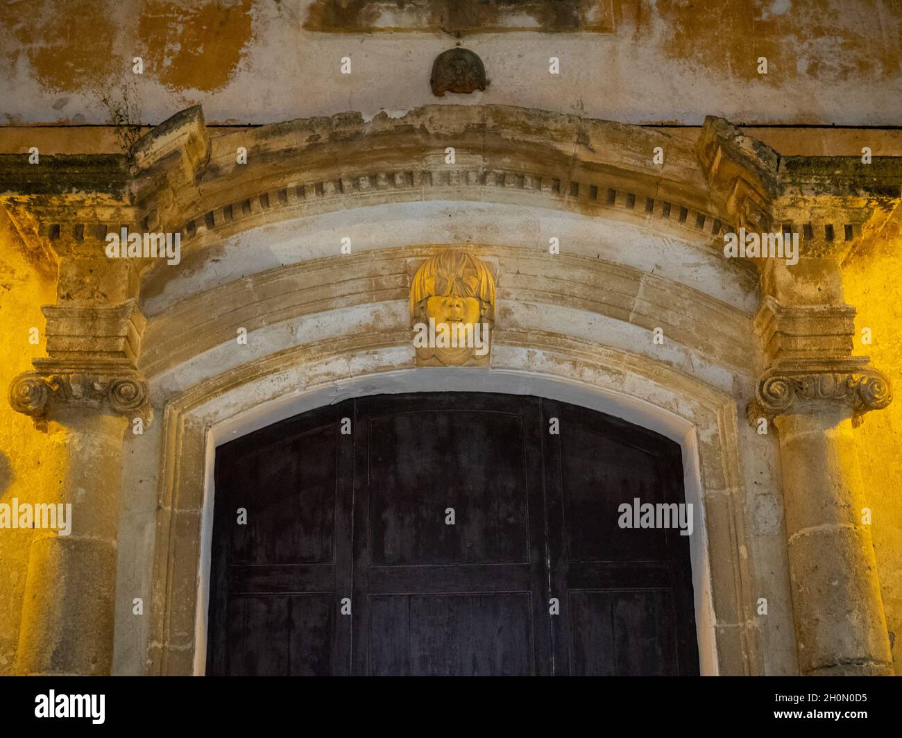 Detail der Tür des Palacio Torresaura mit Schnitzerei eines Kopfes mit verdeckten Augen, Ciutadella Stockfoto