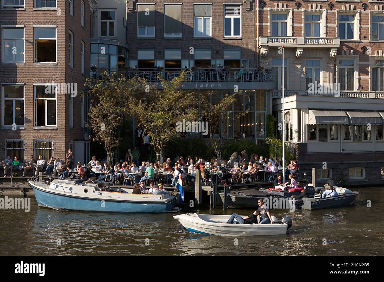 NIEDERLANDE, NORDHOLLAND, AMSTERDAM. VÖLKER AUF DER TERRASSE DES CAFÉS DE JAREN AN EINEM SONNIGEN NACHMITTAG Stockfoto