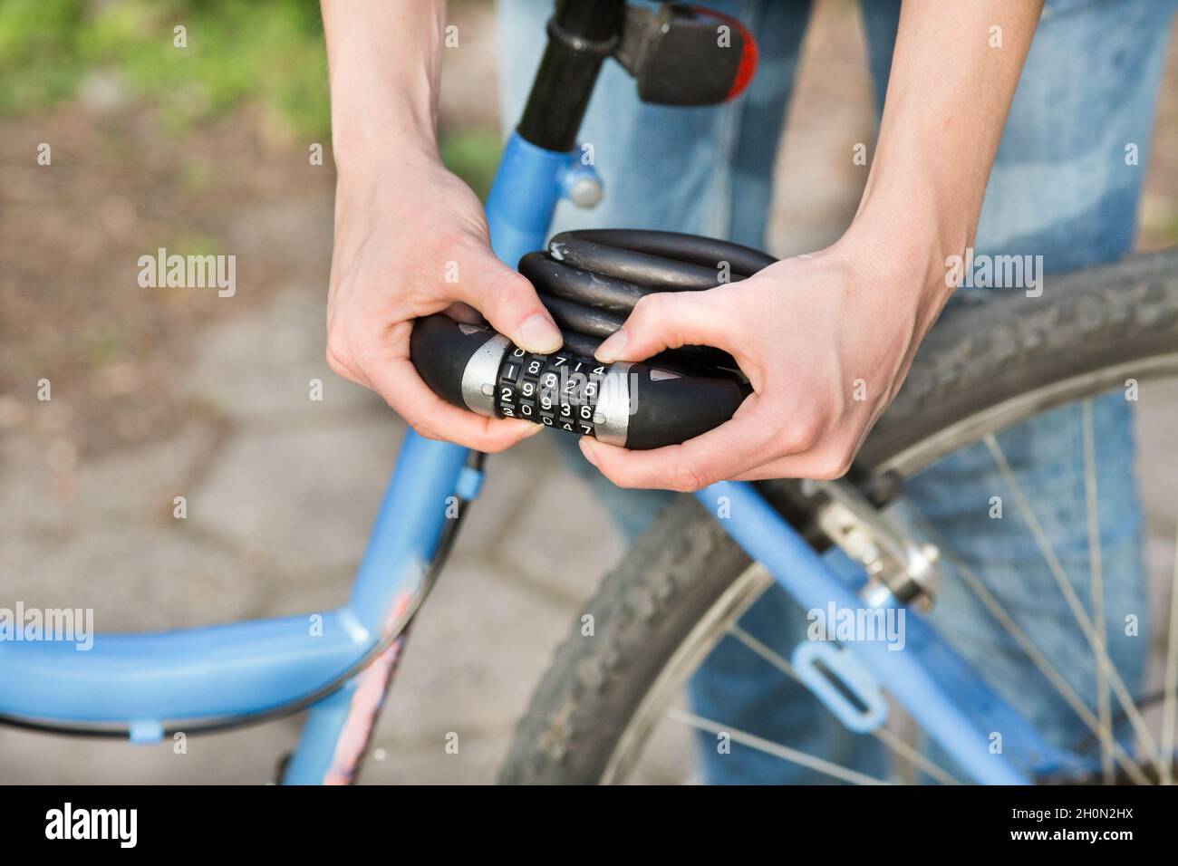 Nahaufnahme der weiblichen Hände, die das Fahrradschloss vor dem Fahrrad halten Stockfoto