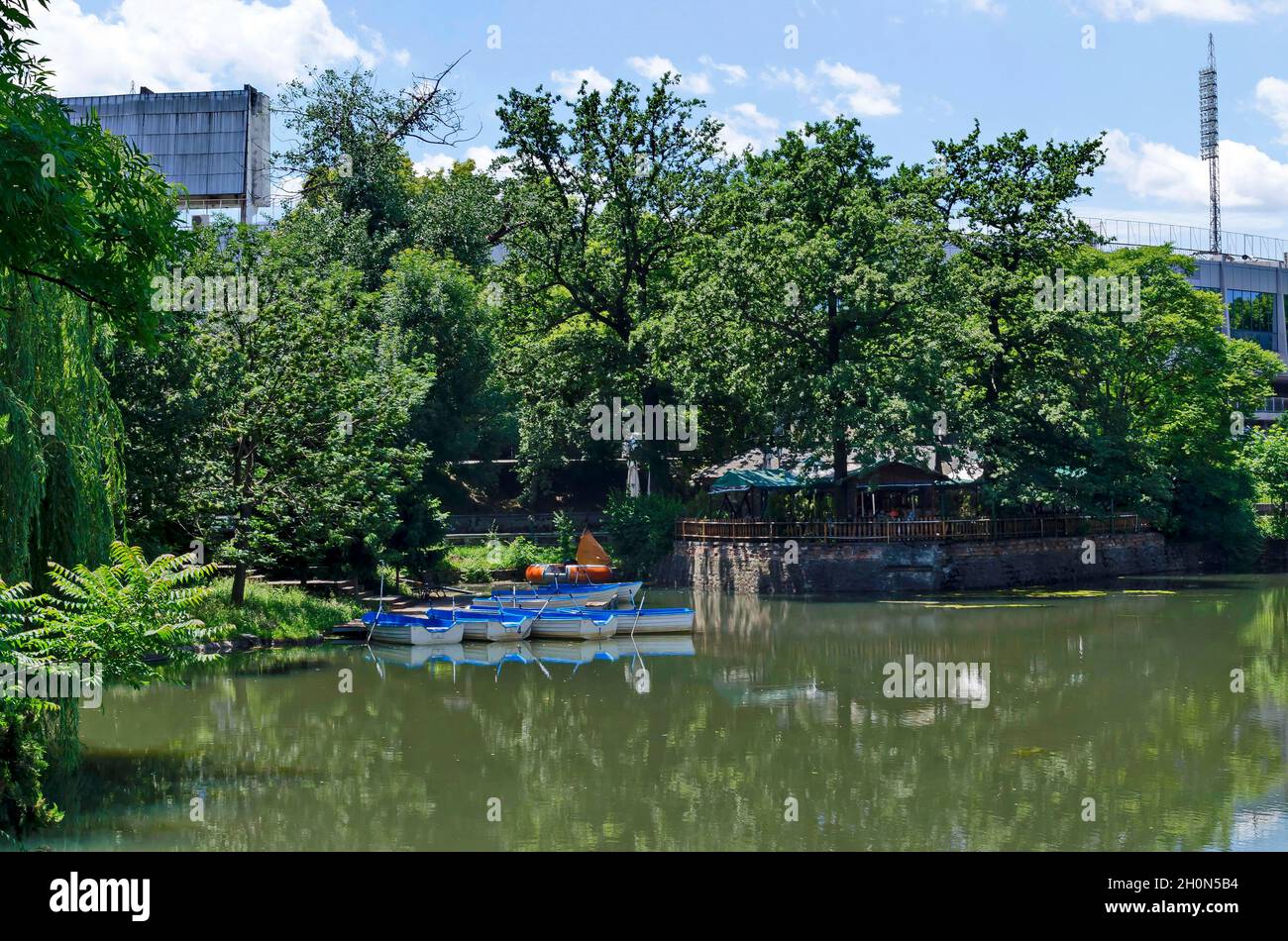 Gemütliche Ecke für Entspannung mit hölzernen Ponton und Boote in See Ariana, Park Borisova gradina, Sofia, Bulgarien Stockfoto