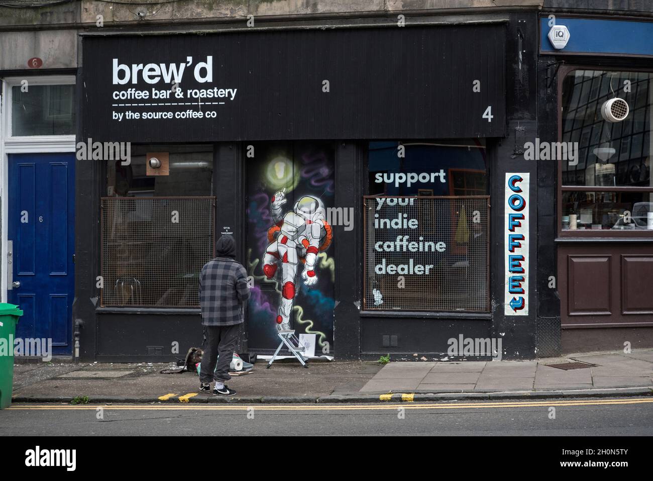 Straßenkünstler, der an einer in Auftrag gegeben Arbeit an der Tür eines unabhängigen Cafés in der Spittal Street, Edinburgh, Schottland, Großbritannien, arbeitet. Stockfoto