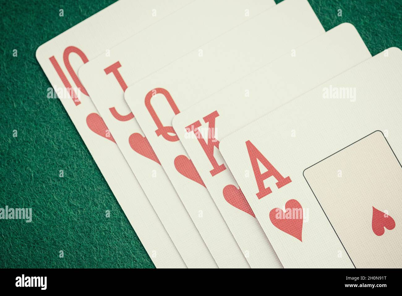 Die Kombination von Spielkarten Poker Casino. Royal Flush in Hearts on Green Card Table Gewinning Hand Business Concept. Stockfoto