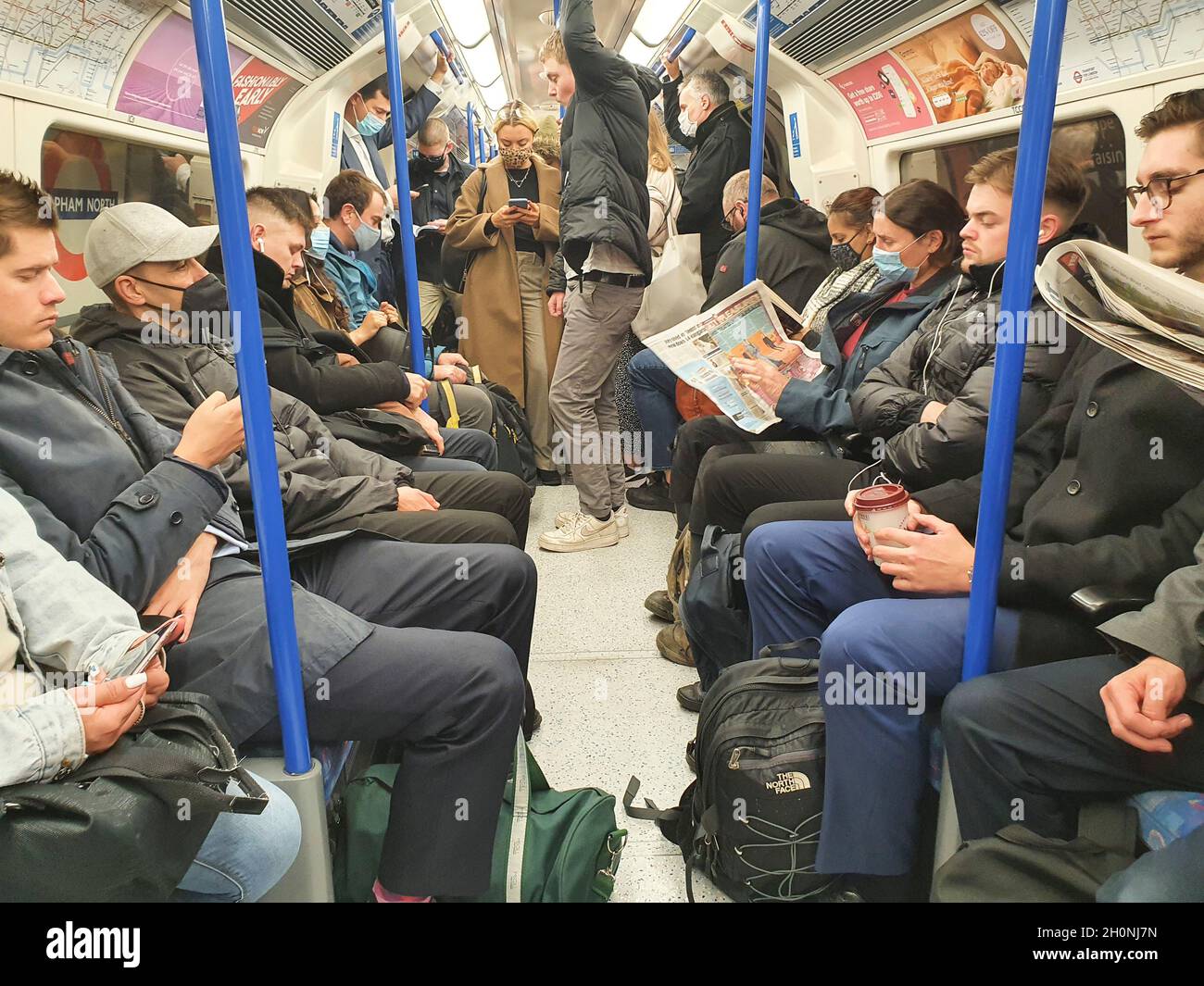 London, Großbritannien, 13. Oktober 2021: Viele Menschen in der Londoner U-Bahn tragen keine Gesichtsmasken mehr, obwohl Transport for London Schilder hat, die die Passagiere daran erinnern, dass eine Gesichtsbedeckung ein Beförderungszustand ist. Menschen dürfen mit öffentlichen Verkehrsmitteln ohne Gesichtsmaske reisen, wenn sie eine medizinische Ausnahme haben, aber die fehlende Durchsetzung bedeutet, dass Maskenlosigkeit weit verbreitet ist. Anna Watson/Alamy Live News Stockfoto