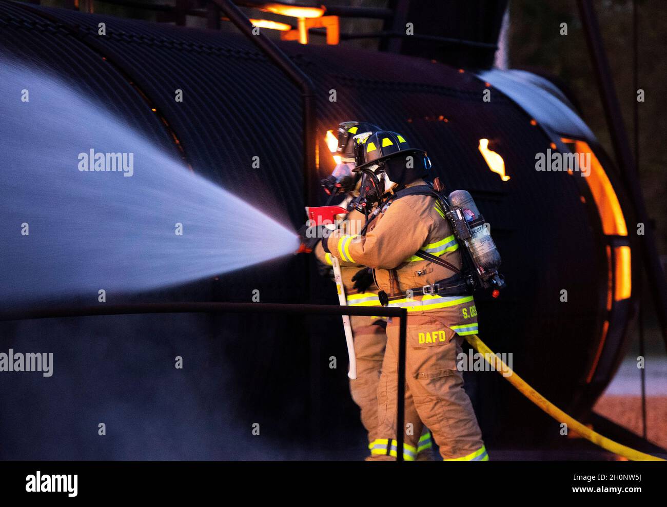 Feuerwehrleute des internationalen Flughafens von Dayton nähern sich einem Trainingsbrand in einem Flugzeugrumpf-Modell am 5. Oktober 2021 auf der Wright-Patterson Air Force Base, Ohio. Die Schulung beinhaltete das Abschlagen des Feuers und den Zugang zum Rumpf zur Rettung. (USA Luftwaffe Foto von R.J. Oriez) Stockfoto