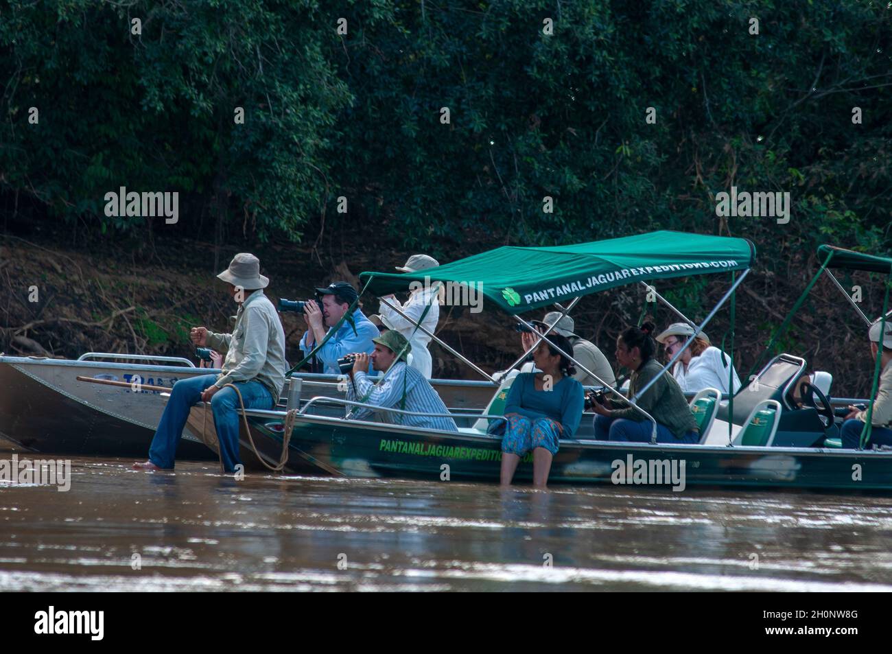 Touristen auf Booten auf der Suche nach Jaguaren auf dem Fluss Tres Irmãos, Pantanal, Mato Grosso, Brasilien Stockfoto
