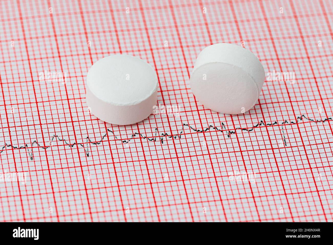 Aspirin auf EKG-Streifen. Konzept für Herzinfarkt, Schlaganfallprävention und Herz-Kreislauf-Gesundheit. Stockfoto