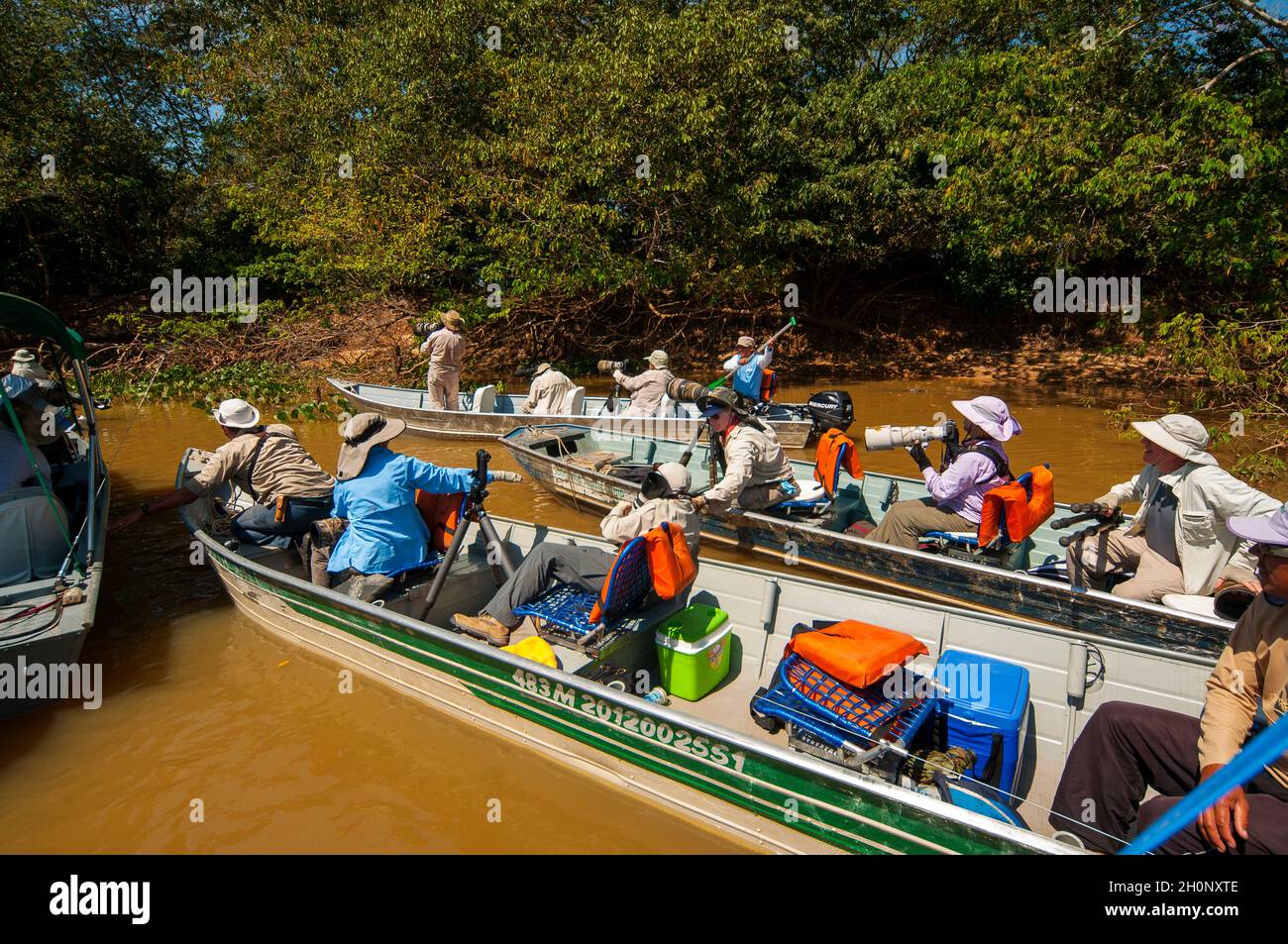 Touristen auf Booten auf der Suche nach Jaguaren auf dem Fluss Tres Irmãos, Pantanal, Mato Grosso, Brasilien Stockfoto