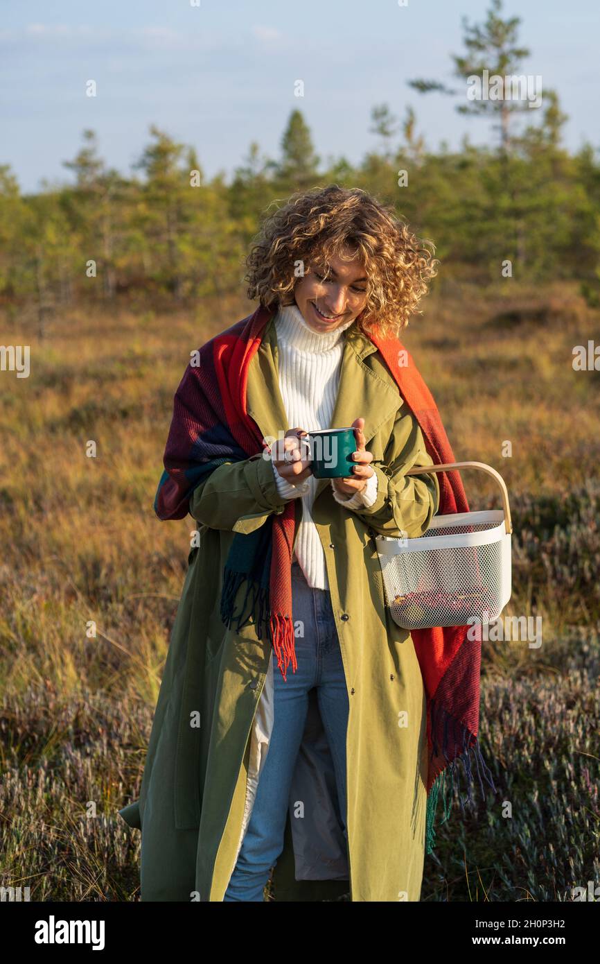 Fröhliches Mädchen in Graben warme Hand auf heiße Tasse Tee verbringen Wochenende genießen sonnigen Herbst auf dem Land Stockfoto