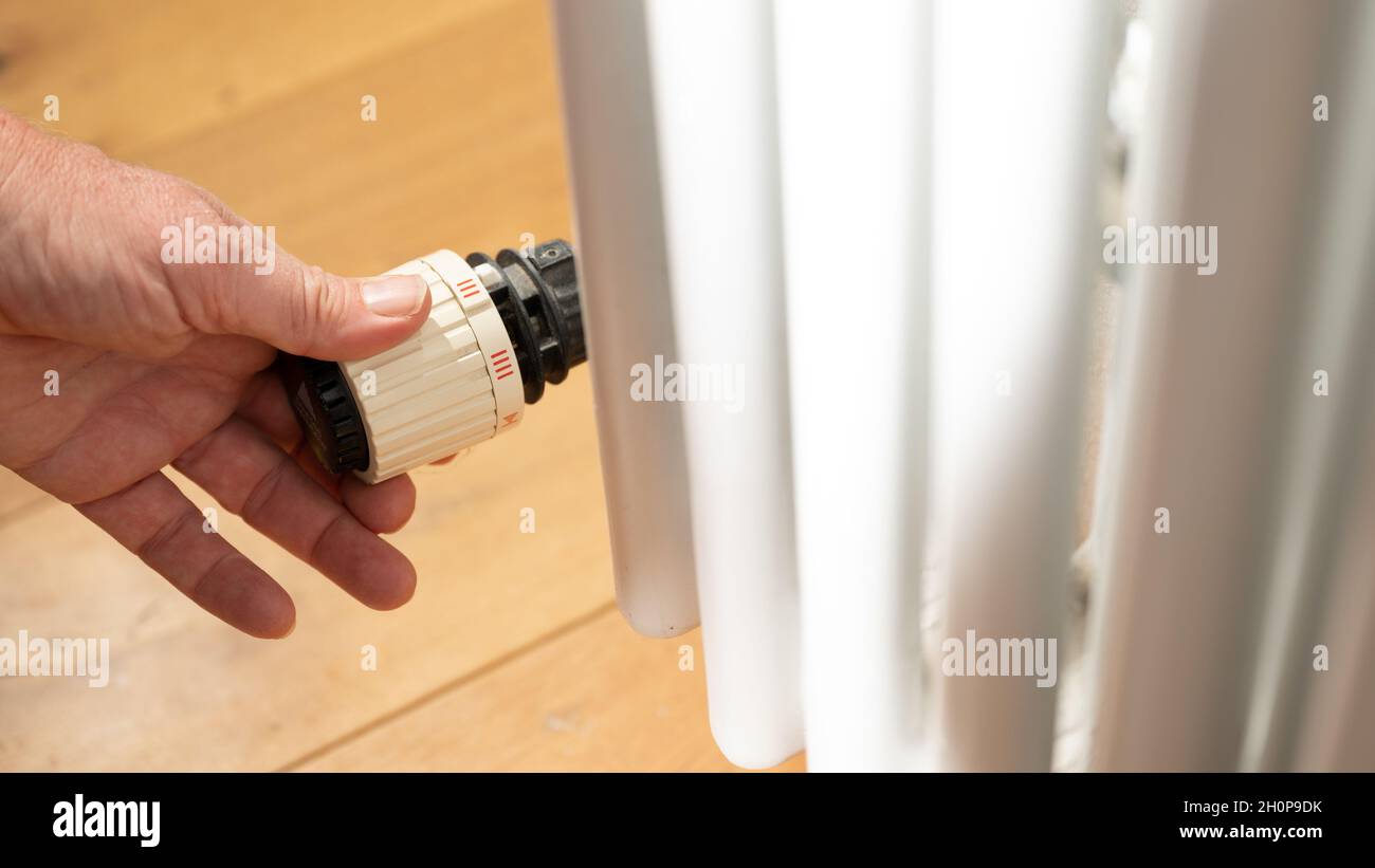 Stuttgart, Deutschland. Oktober 2021. Eine Hand regelt einen Thermostat auf einer Heizung in einer Wohnung. Aufgrund steigender Energiepreise werden die Heizkosten immer teurer. Quelle: Bernd Weißbrod/dpa/Alamy Live News Stockfoto