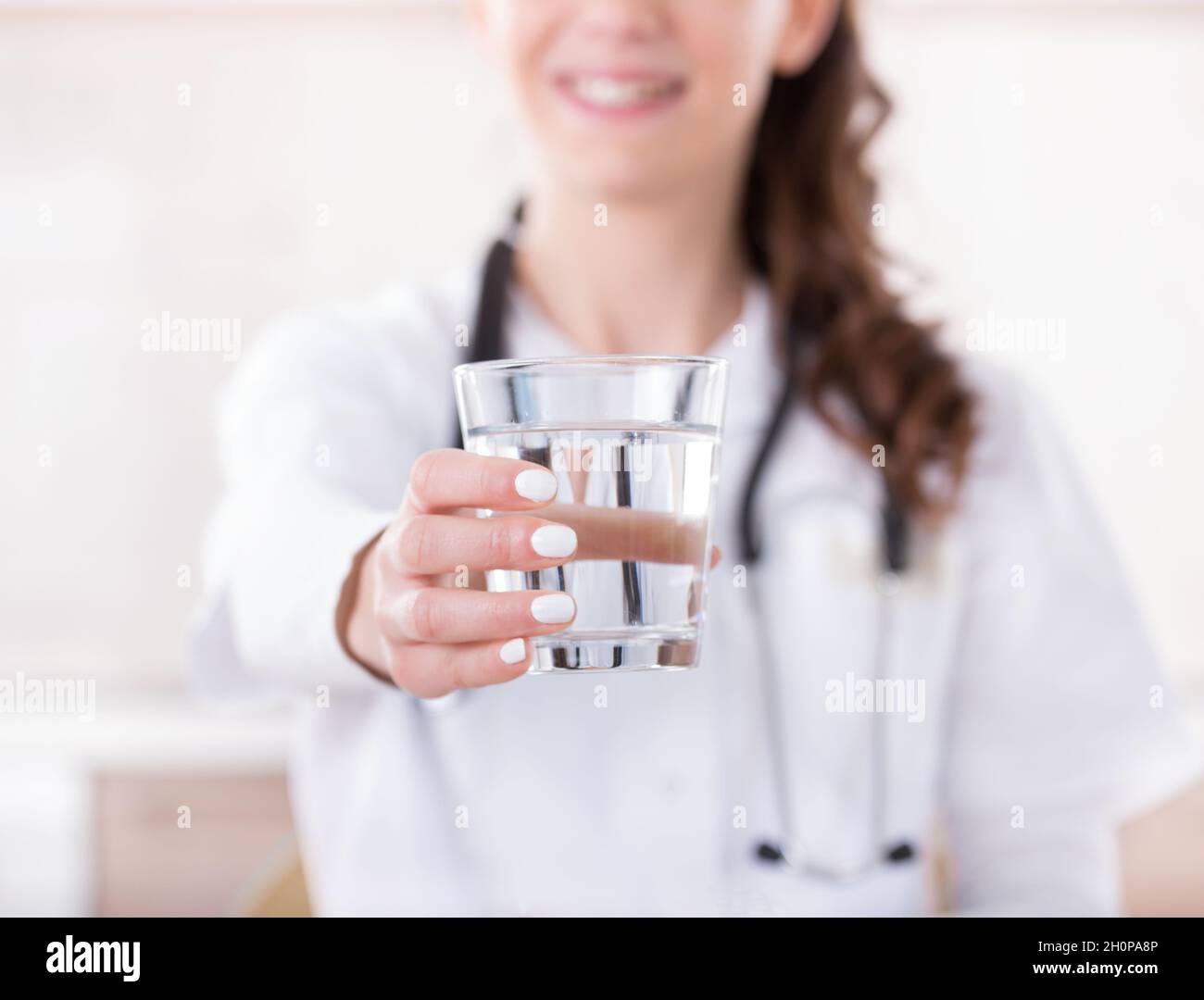 Nahaufnahme der Hand einer Ärztin mit einem Glas Wasser Stockfoto