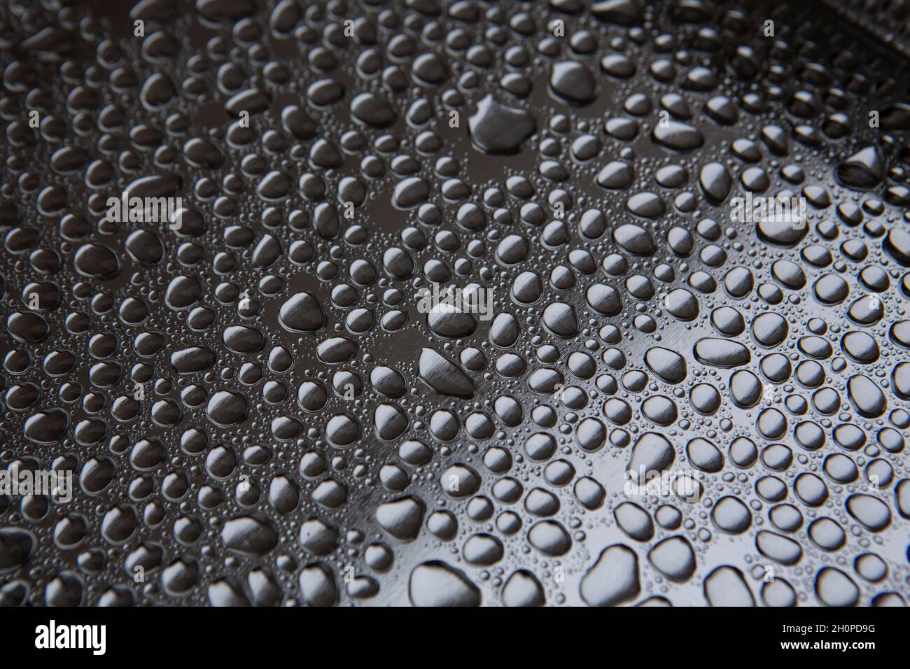 Wassertropfen regen Tropfen auf einem silbernen Metalltablett Stockfoto
