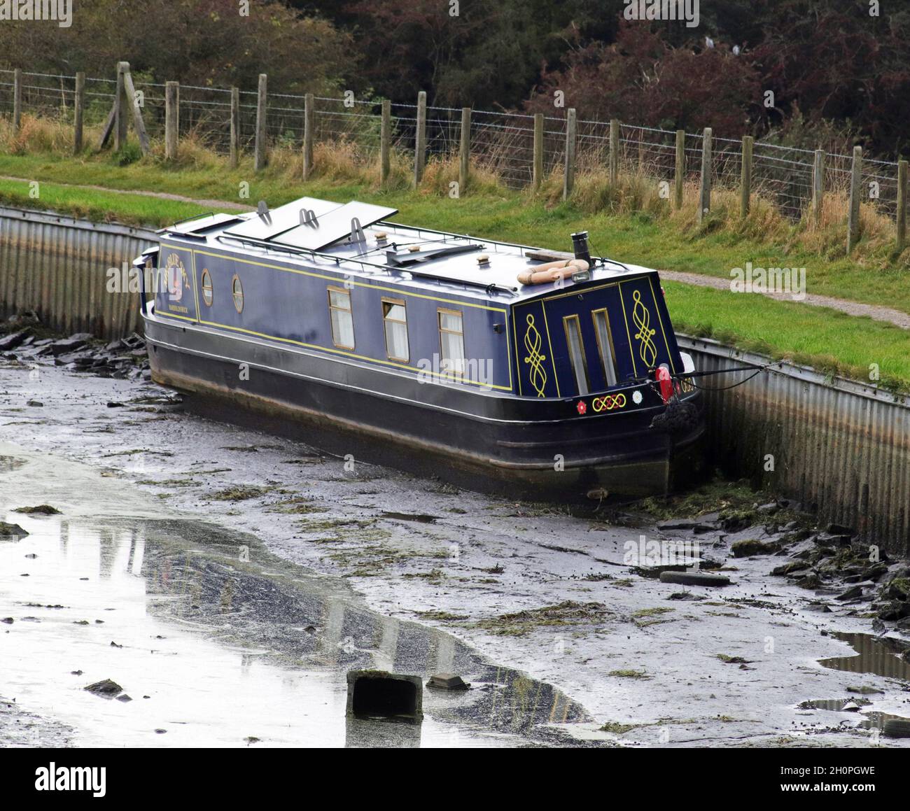 Am 11.10.21 ereignete sich ein Bruch im Leeds und Liverpool Kanal in der Nähe von Rishton in East Lancashire, bei dem dieses Boot ohne Wasser zum Schwimmen gestrandet war. Stockfoto
