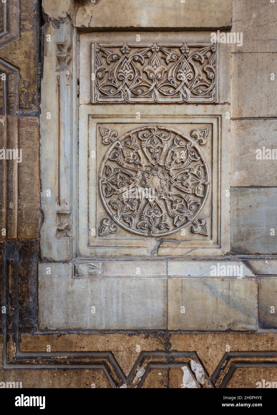 Runde florale Muster durch geometrische Muster in den äußeren alten Steinmauer von Sultan Hasan Moschee, Kairo, Ägypten, geschnitzte gerahmt Stockfoto