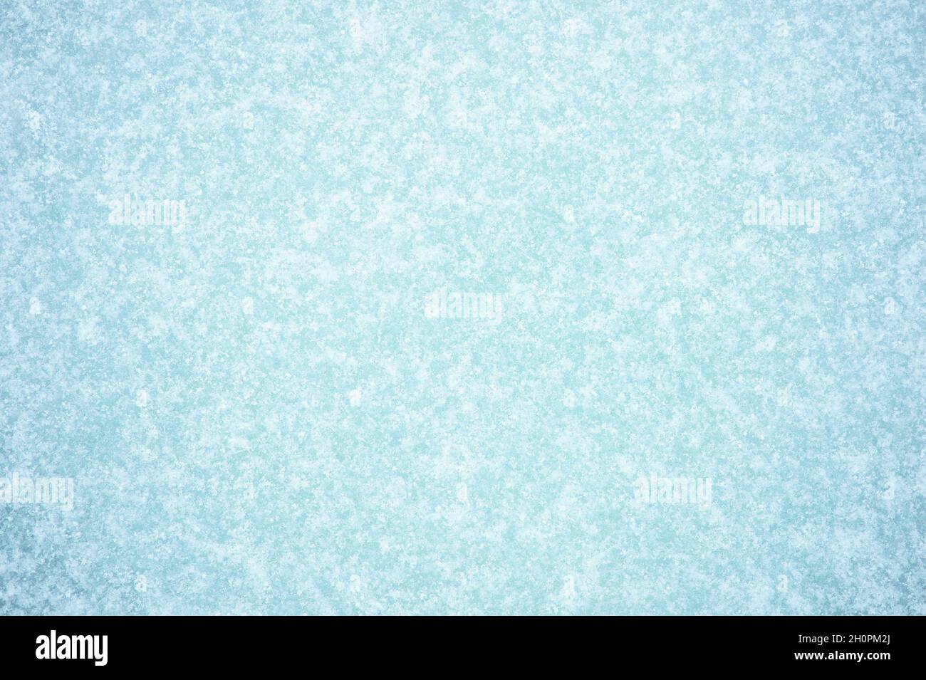 Ein schneebedecktes Frostmuster auf blauem Eis. Natürlicher Hintergrund. Stockfoto