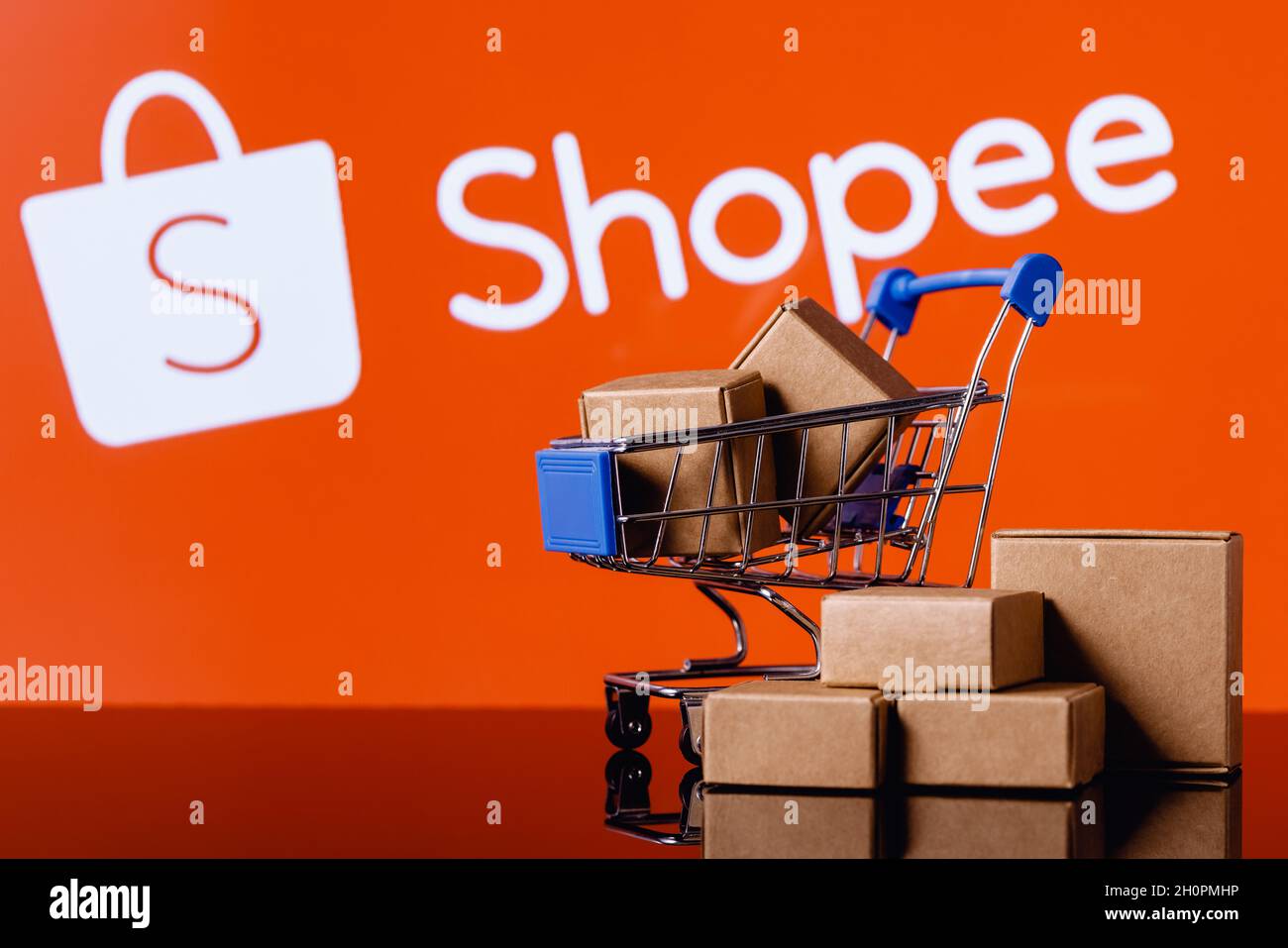 Shopee ist ein E-Commerce-Technologieunternehmen. Warenkorb mit Paketen auf dem Hintergrund des Shopee-Logos. Stockfoto