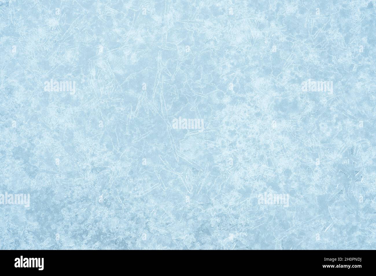 Das hellgrau-blaue Eis ist strukturiert mit einem leuchtenden lockigen Muster von Eisadern im weißen Frost. Hintergrund. Stockfoto