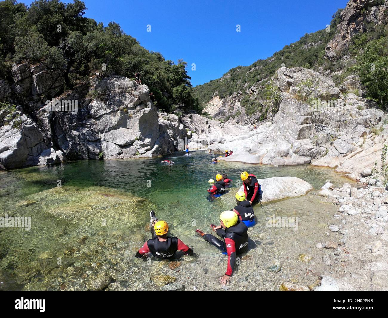 Canyoning am Travo-Fluss im Süden Korsikas. Gruppe mit Neoprenanzügen und Helmen Stockfoto