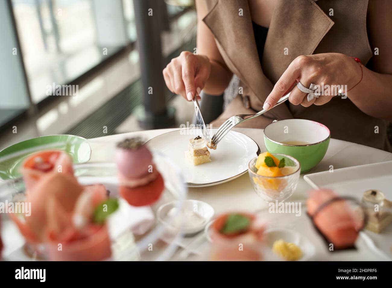 Nahaufnahme der Hände einer asiatischen Kundin, die Desserts in einem Restaurant mit Feinschmeckerrestaurant isst Stockfoto
