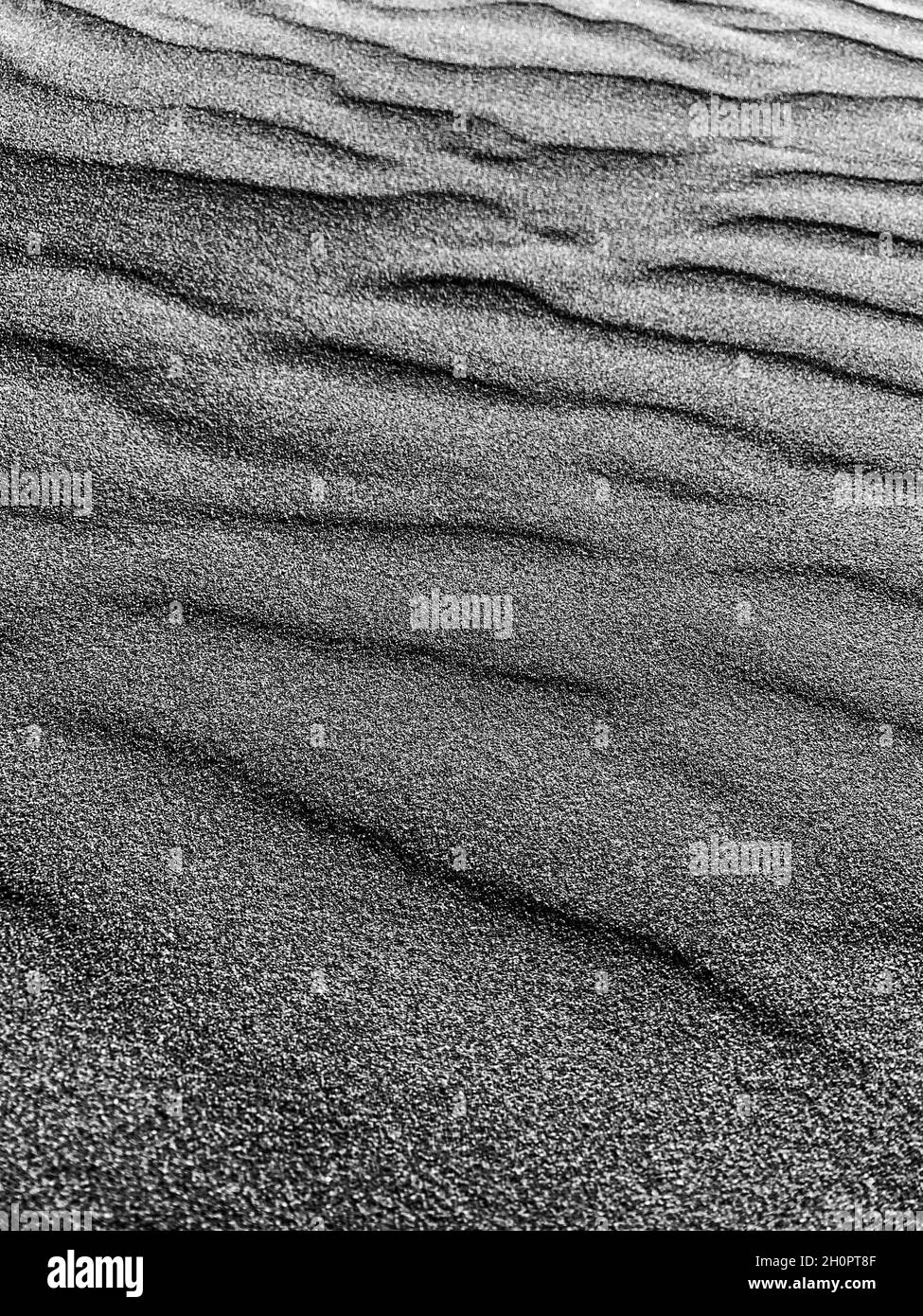 Abstrakter schwarzer Sandhintergrund. Dunkle Sandwellen Stockfoto