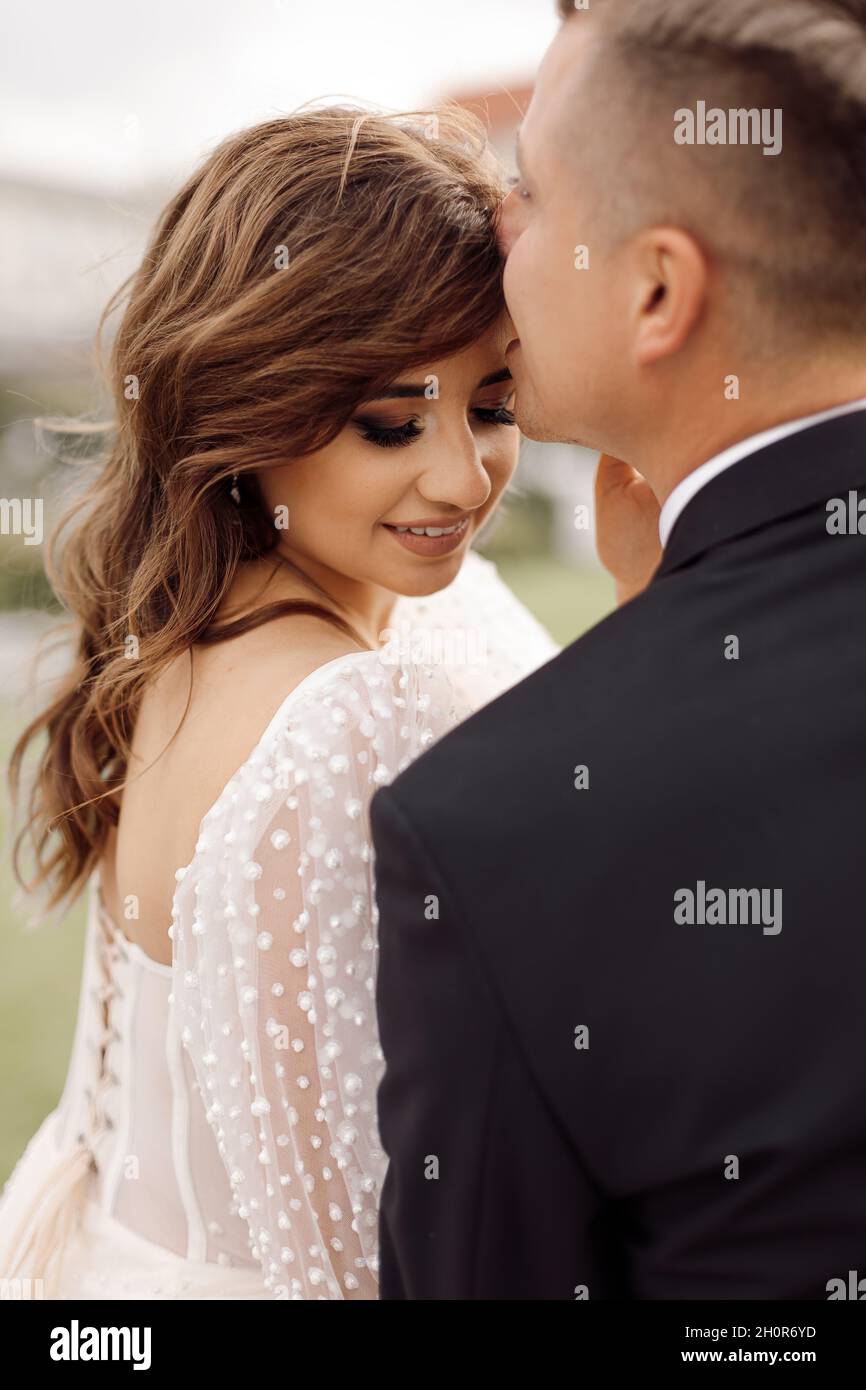 Porträt des Hochzeitstages. Romantische sanfte Berührung, Konzept der Liebe und glückliche Ehe. Berührende Haltung des jungen Paares. Porträt von Braut und Bräutigam. Li Stockfoto