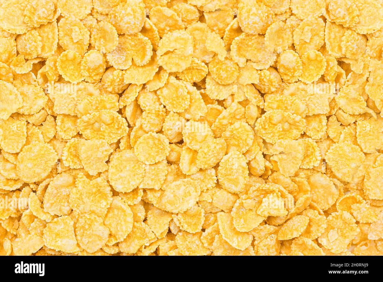 Hellgelbe Maisflocken-Textur als Hintergrund. Cerealien-Box von oben für das Frühstück aus nächster Nähe. Stockfoto