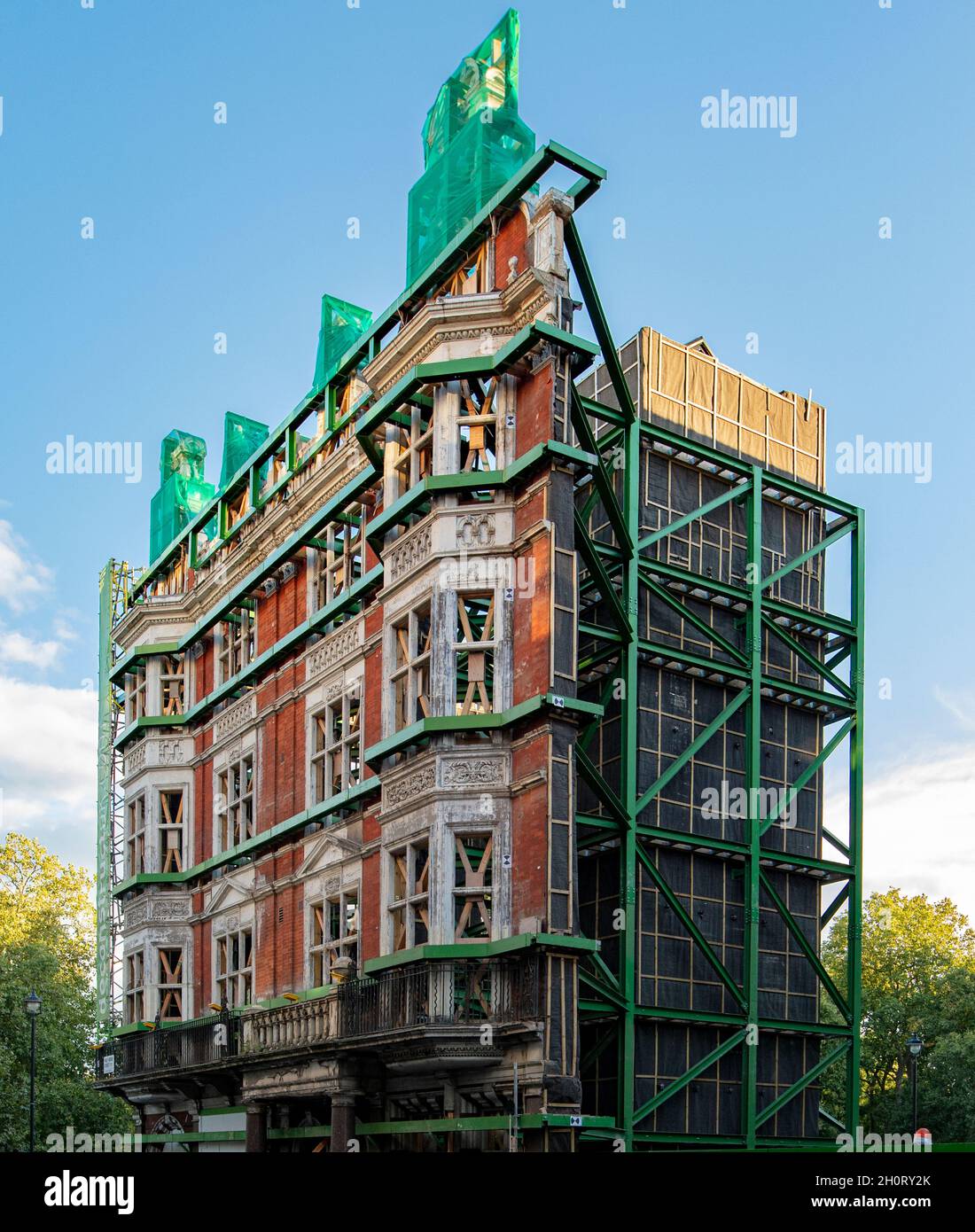 Die Fassade eines großen Gebäudes am Piccadilly in London wird gerade renoviert; die Fassade ist erhalten und hinter ihr erscheint eine moderne Konstruktion. Stockfoto
