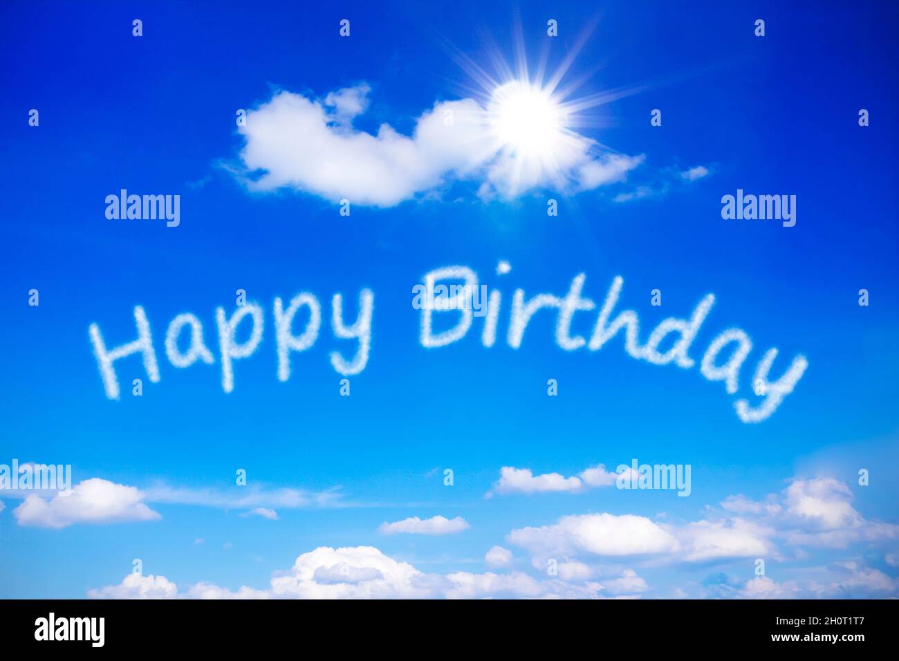Happy Birthday geschrieben an einem sonnigen blauen Himmel, Symbol für die besten Wünsche für einen unbeschwerten besonderen Tag mit endloser Sonne. Hintergrundvorlage. Stockfoto