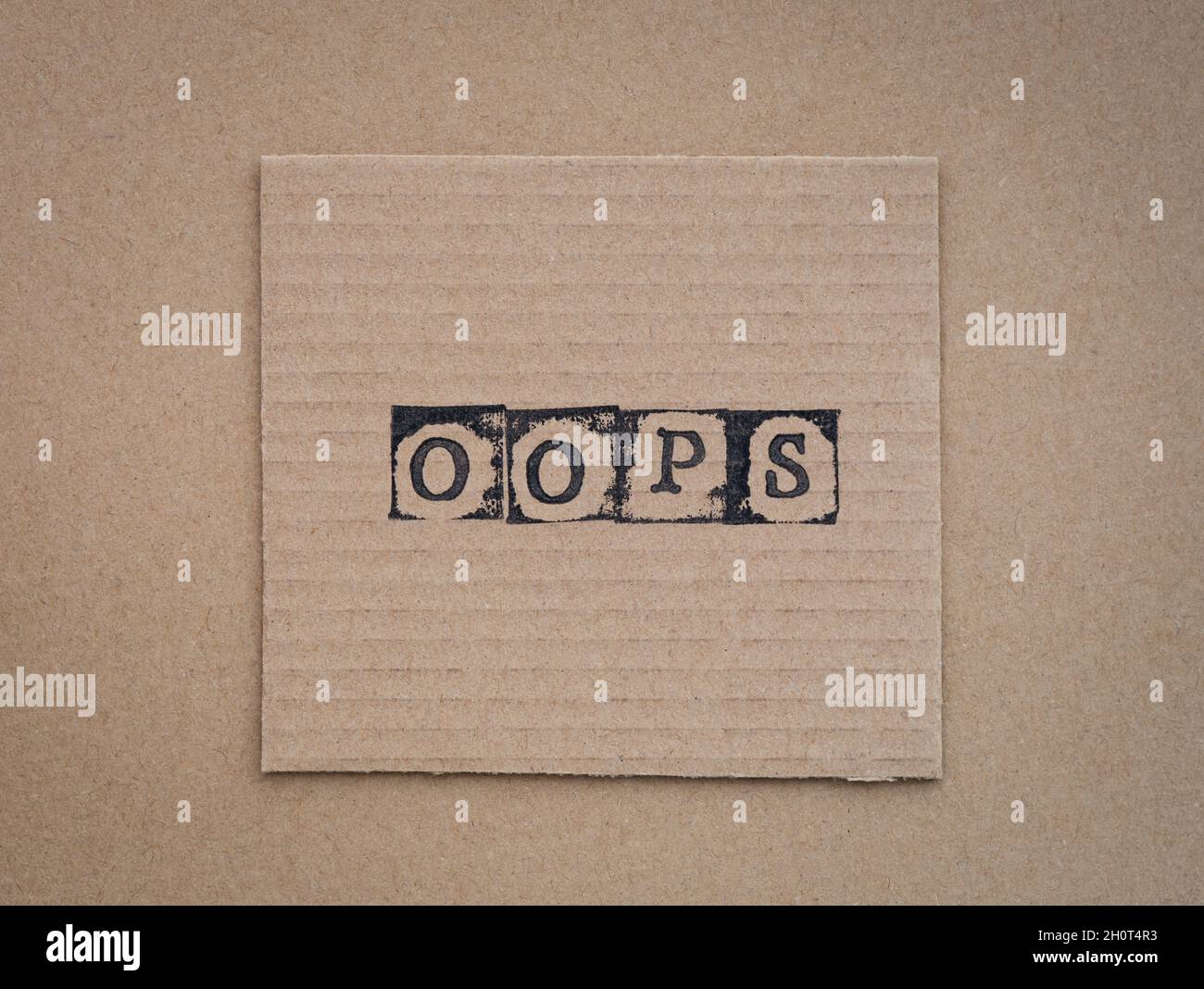 Karton mit Wort Hoppla, hergestellt von schwarzen Alphabet-Marken. Stockfoto