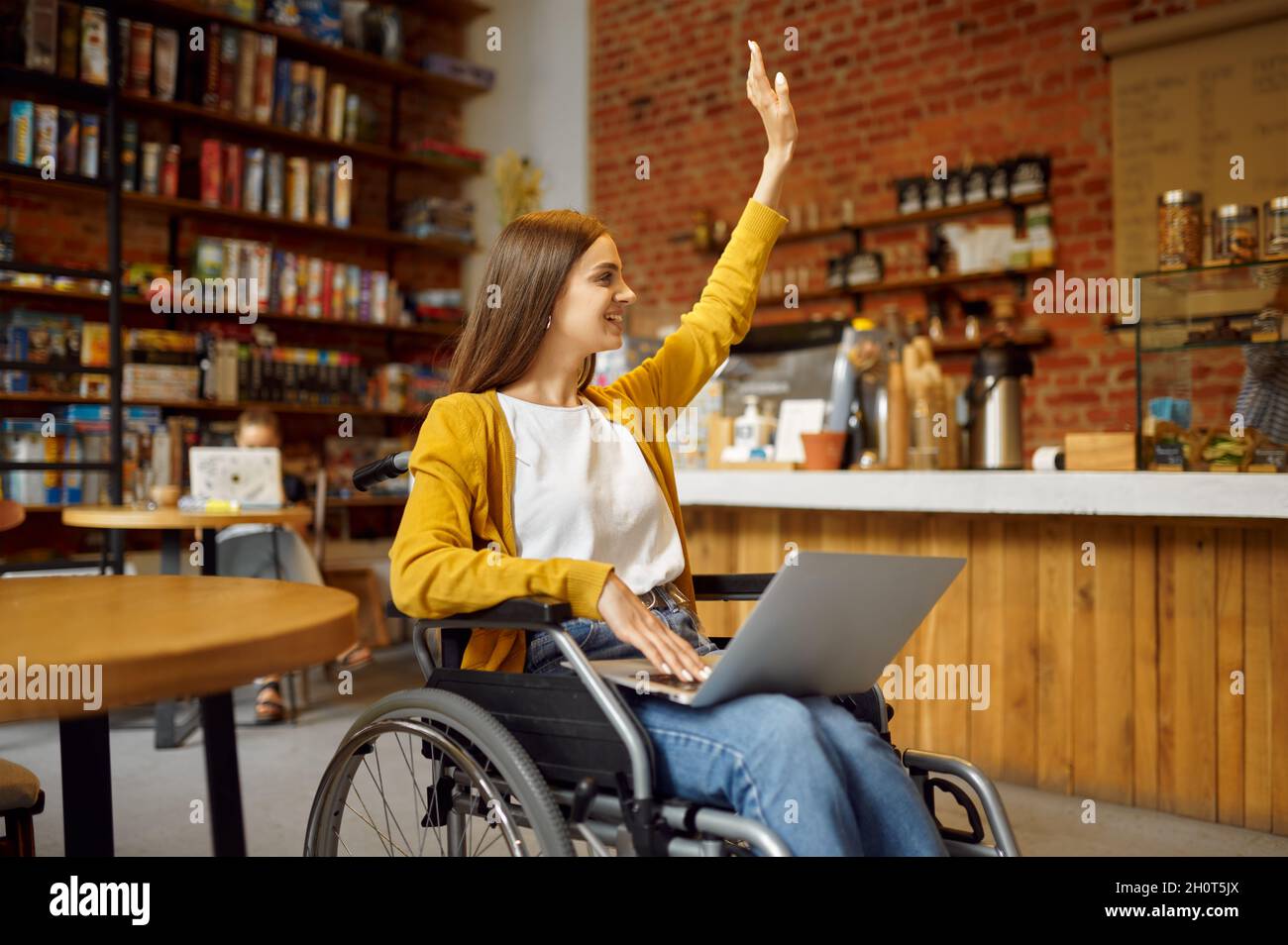 Behinderter Schüler im Rollstuhl mit erhobener Hand Stockfoto