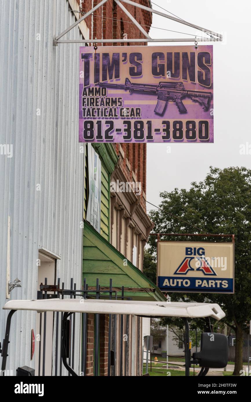 Auf einem violetten Schild auf dem Aluminiumgebäude steht: Tim’s Guns, Ammo, Firearms, Tactical Gear. Im Hintergrund ist ein Schild für Big A Auto Parts, Worthington, in. Stockfoto
