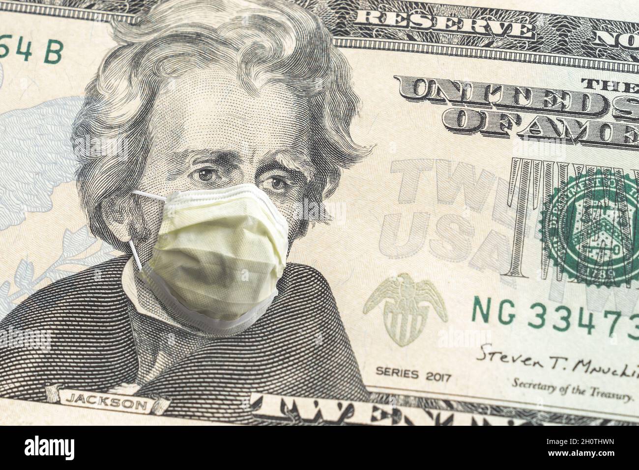 Nahaufnahme der US-amerikanischen Papierwährung 20-Dollar-Rechnung mit Andrew Jackson in gelber Gesichtsmaske wegen der COVID-19-Pandemie, die einen großen Finan machte Stockfoto