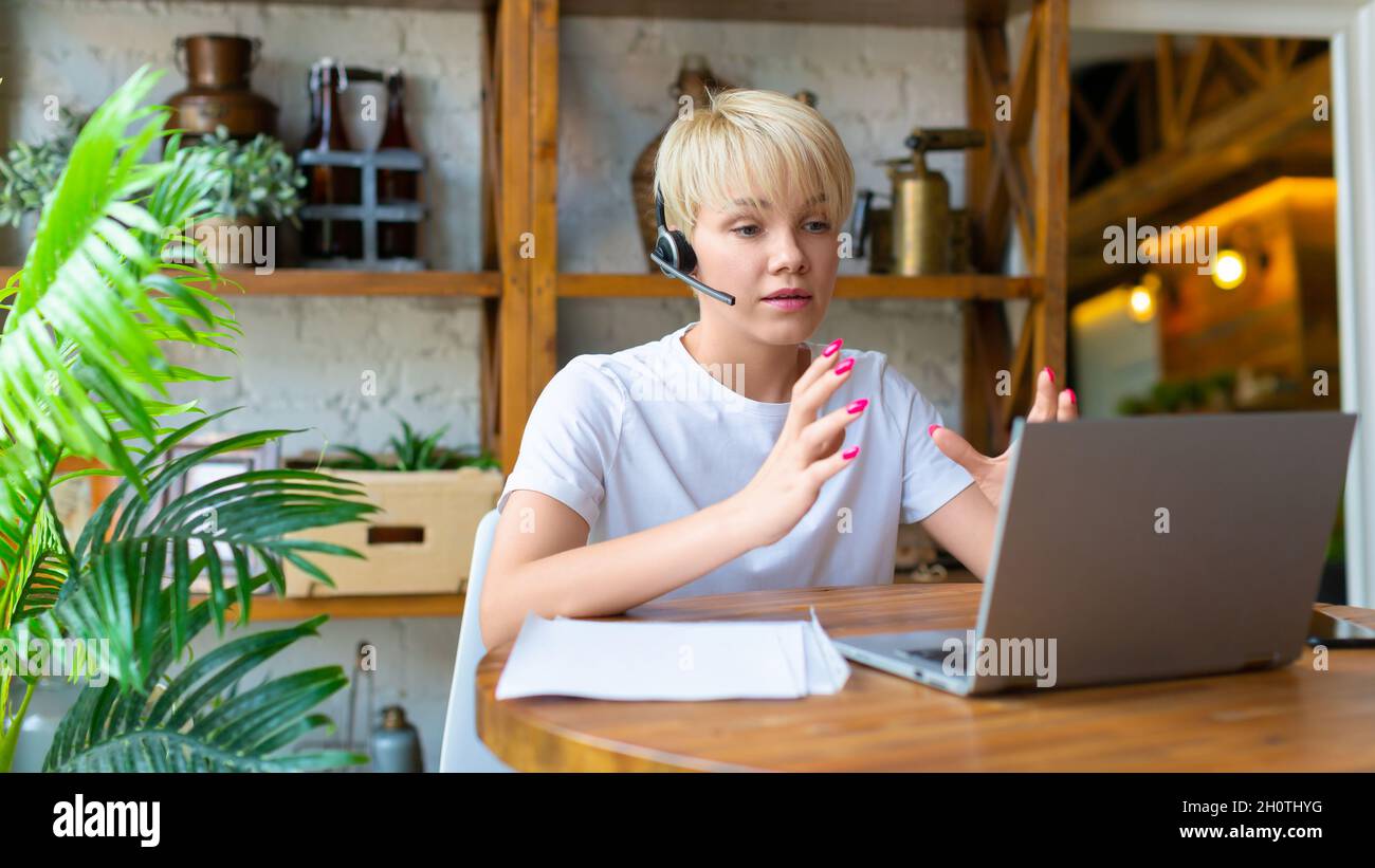 Junge Frau, die zu Hause arbeitet - sie hat einen Online-Videoanruf. Foto im Innenraum des Hauses. Stockfoto