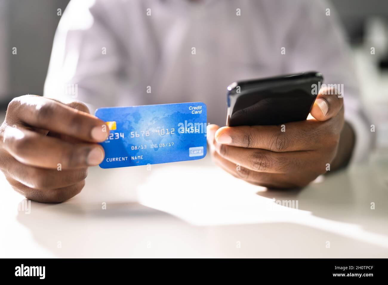 Person Mit Kreditkarte Und Mobiltelefon Beim Online-Banking Stockfoto